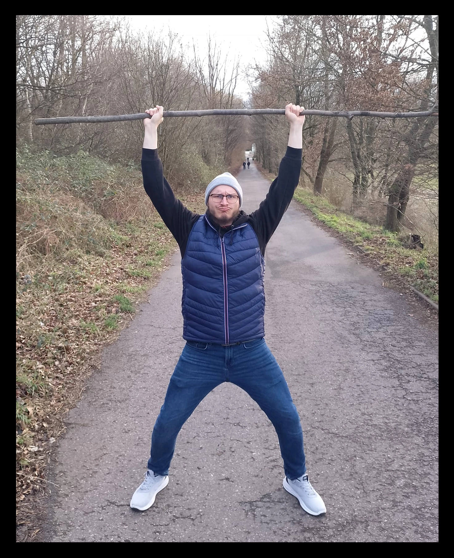 A picture of me with a big stick in both hands.